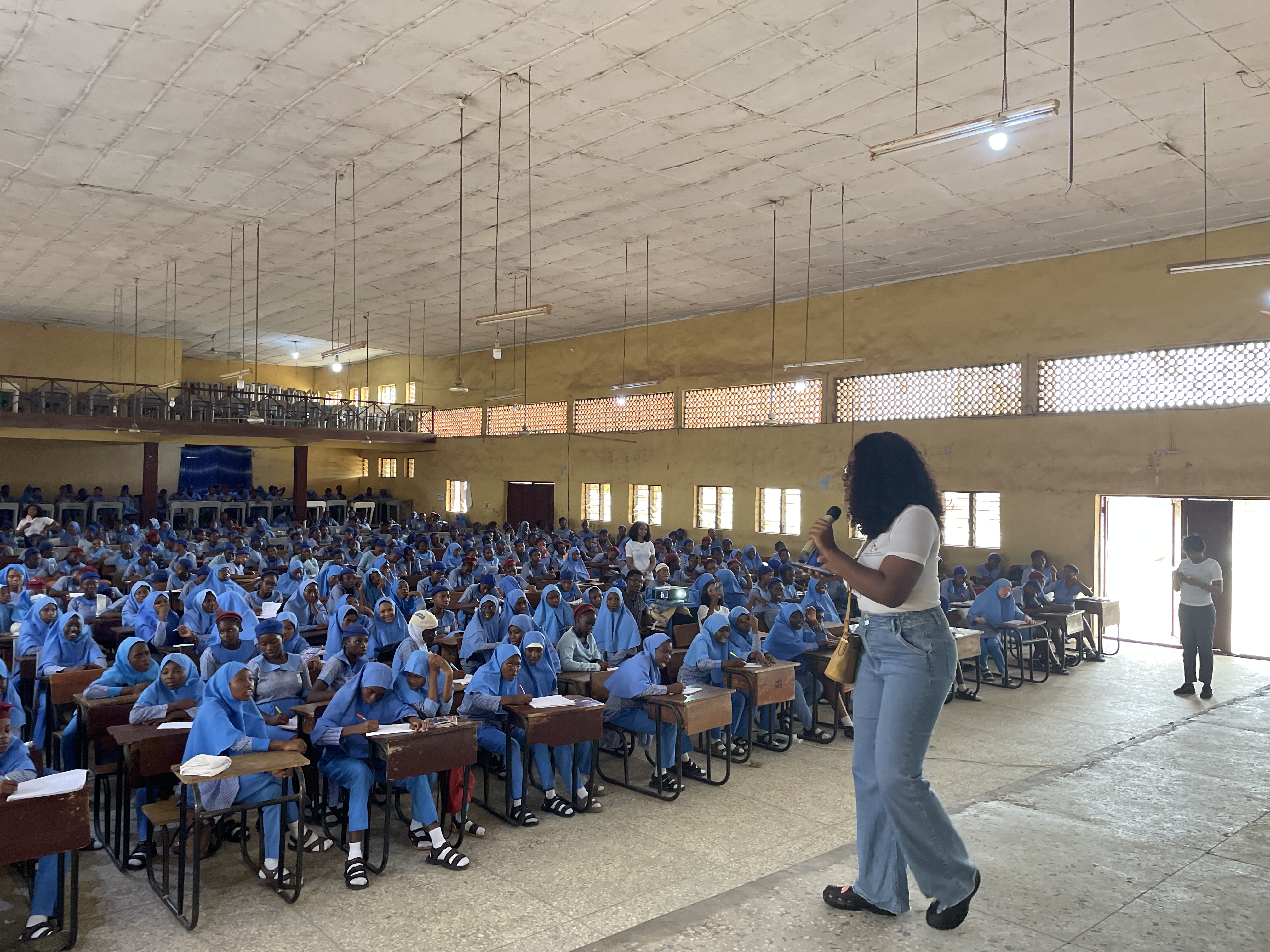 A speaker addresses students at a school assembly